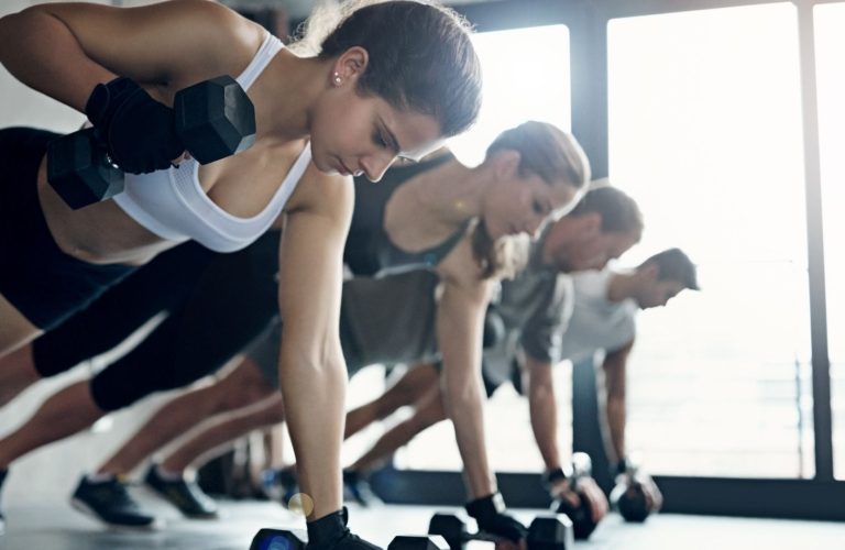 Férfi és nő edzőteremben hátgyakorlatot végez