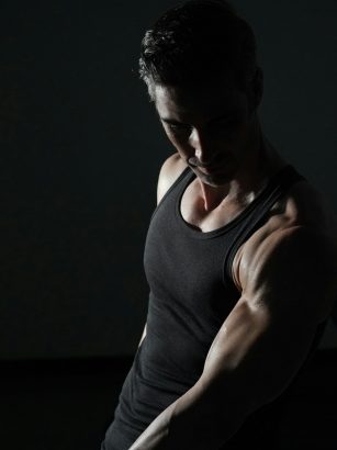 a man in a black tank top is doing exercises