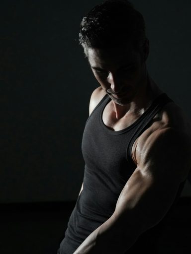 a man in a black tank top is doing exercises