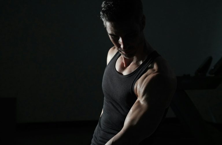 a man in a black tank top is doing exercises